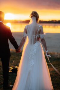Braut in einem Brautkleid mit Spitzenrücken und fließendem Rock