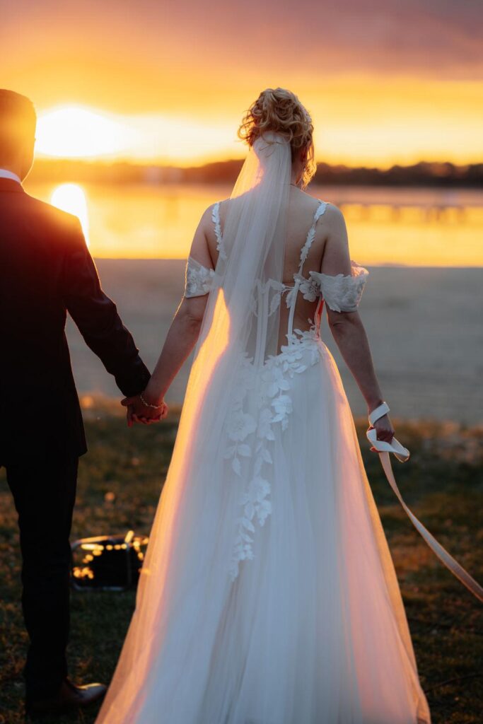 Braut in einem Brautkleid mit Spitzenrücken und fließendem Rock