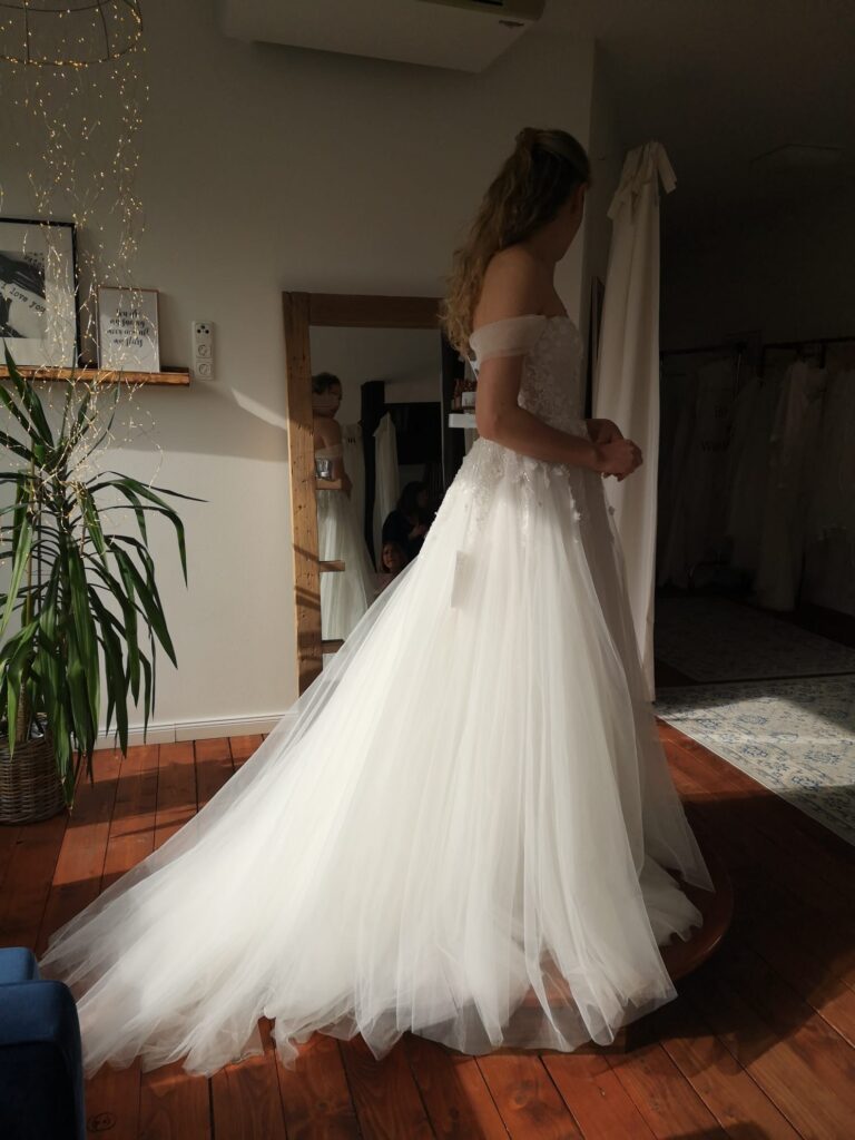 Braut im Brautkleid vor dem Spiegel bei ihrer Anprobe im Hochzeitsspeicher an der Elbe